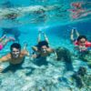 Family snorkeling together in clear waters