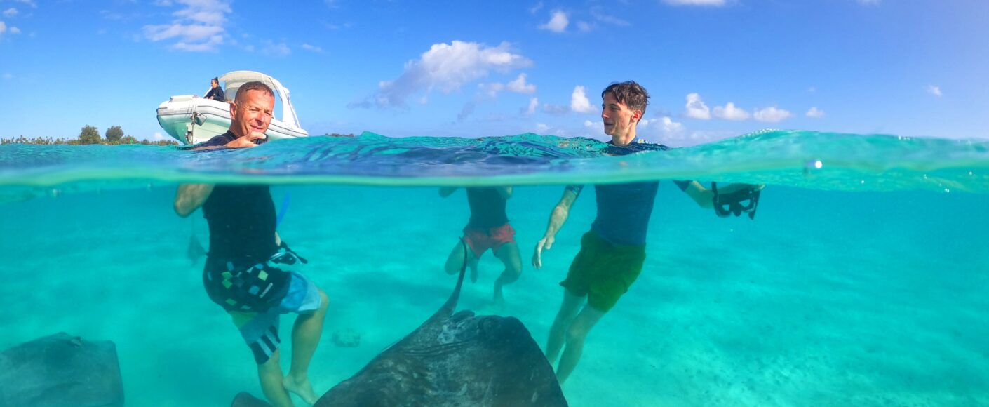 Snorkeler diving with manta rays in Tuamotu Atoll
