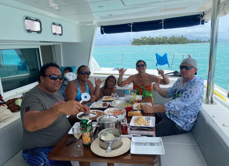 Group enjoying Polynesian-style BBQ on a boat