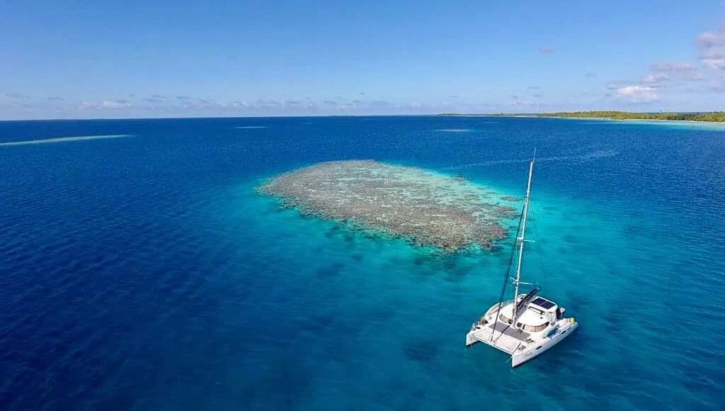 Private catamaran anchored in turquoise french polynesia