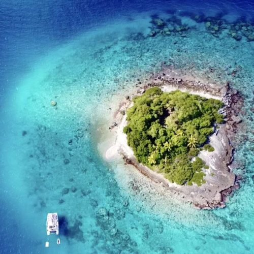 Catamaran docked near a secluded beach in Tahiti